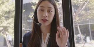 迷人的年轻亚洲商务女性有视频电话和与客户交谈