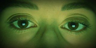 白人女性眼睛与绿色计算机代码