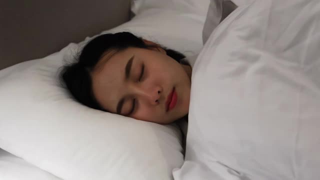 睡在床垫上的亚洲女人