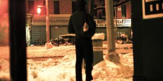 一个人站在城市街区的雪地里