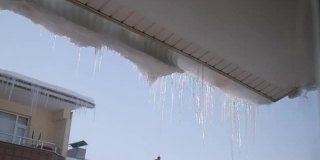 融化的冰柱和屋顶上的阳光