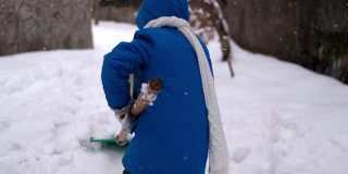 小男孩在冬天铲雪。
