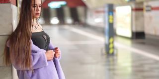 靠在墙上的模特女孩在合成皮草大衣裸露她的肩膀在地铁或地铁站台等待慢动作。女性奢华的化妆，长发和时尚的服装。FHD视频