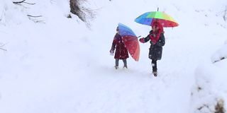 小女孩们在雪下玩耍