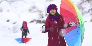 小女孩们在大雪中打着五颜六色的伞