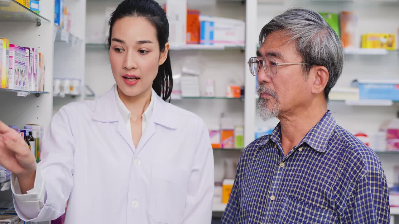 一位高级男子在药店和女药剂师交谈。女药师在药房协助向老年病人客户讲解药物。