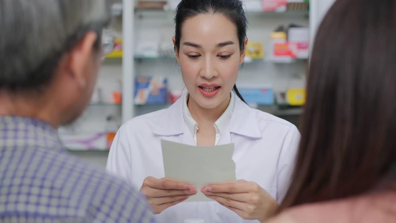 自信的亚洲药剂师在药店室内对客户谈论药物。
