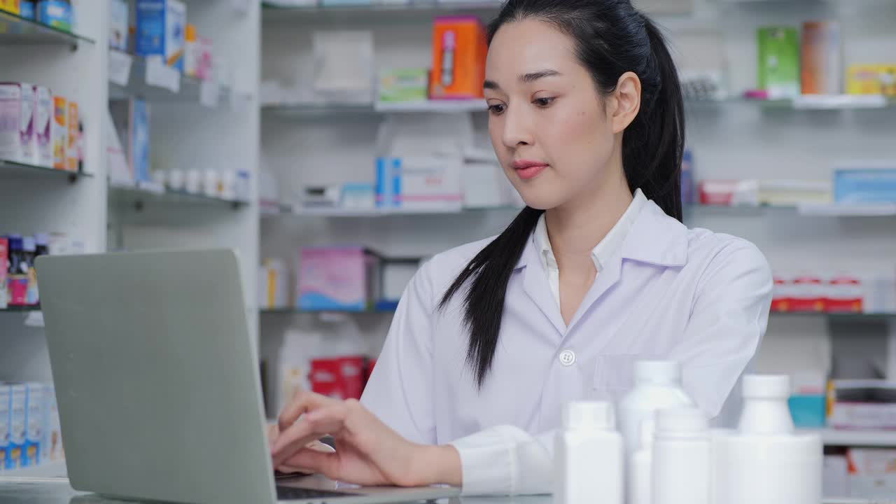 女医生在药店研究药品细节。她用电脑寻找信息。