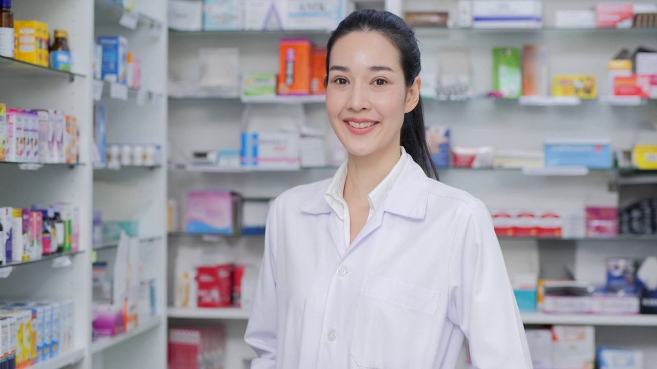 年轻的亚洲医生摆姿势与相机在药店微笑。