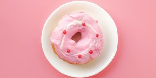 定格动画甜甜圈咬粉红色的背景