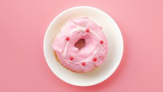 定格动画甜甜圈咬粉红色的背景视频素材模板下载