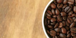 黑咖啡豆会旋转。咖啡豆的特写。美丽的咖啡种子。