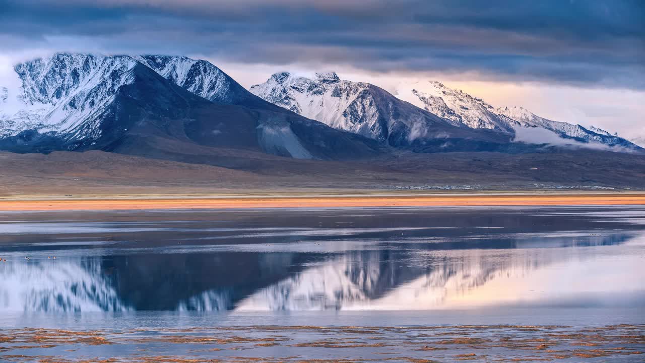 西藏的雪山倒映在湖面上，使湖面变得柔和而美丽