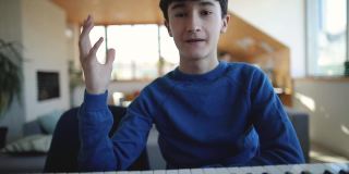 十几岁的男孩录制视频教程关于在家里玩合成器