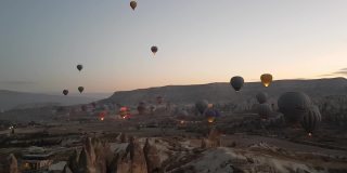 彩色的热气球上升并漂浮在土耳其卡帕多西亚山区的天空中