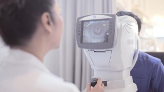 成熟的女性验光师在老年病人身上使用光视仪视频素材模板下载