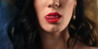 特写性感的黑发女人舔舌头，咬红色的嘴唇摆迪斯科散拍。4k Dragon RED摄像机