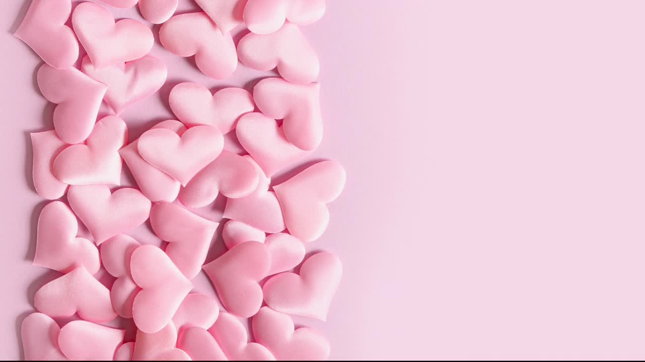 粉红色的情人节心形像画框一样在粉色的屏幕上移动。