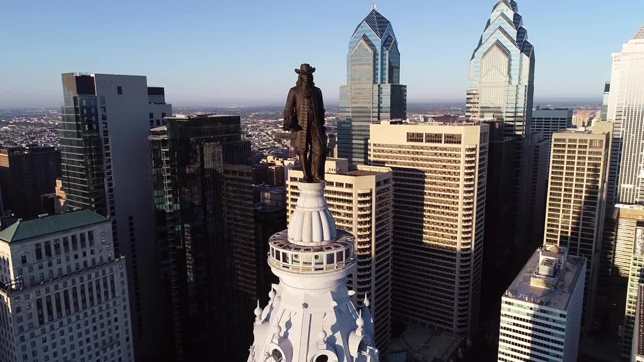 费城市政厅大楼和威廉·佩恩的青铜雕像。城市风景和美丽的日落背景