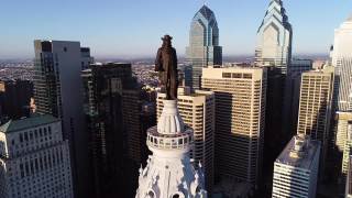 费城市政厅大楼和威廉·佩恩的青铜雕像。城市风景和美丽的日落背景视频素材模板下载