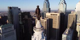 费城市政厅大楼和威廉·佩恩的青铜雕像。城市风景和美丽的日落背景
