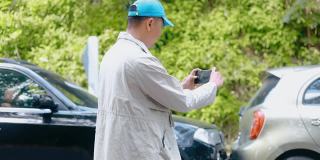 HD Man保险代理人用智能手机拍摄车祸照片。两辆破车接连停在路上