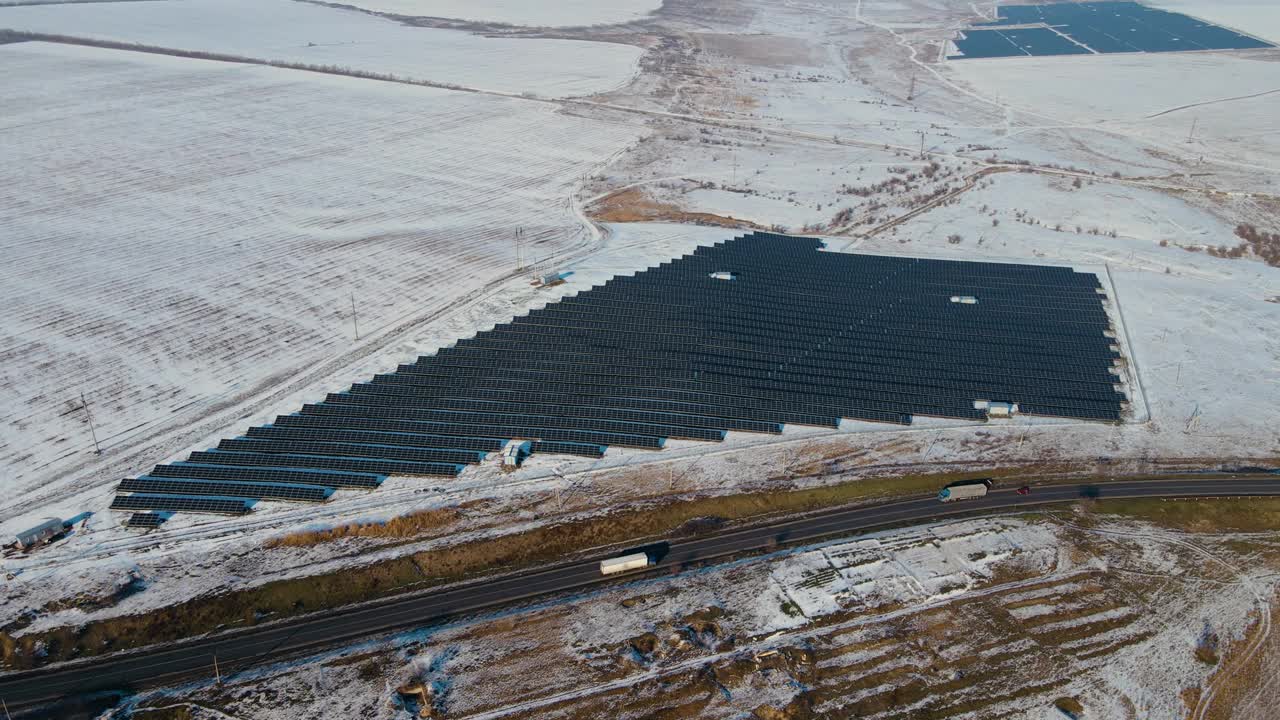太阳能电池站在雪地附近的高速公路在冬季移动重型卡车