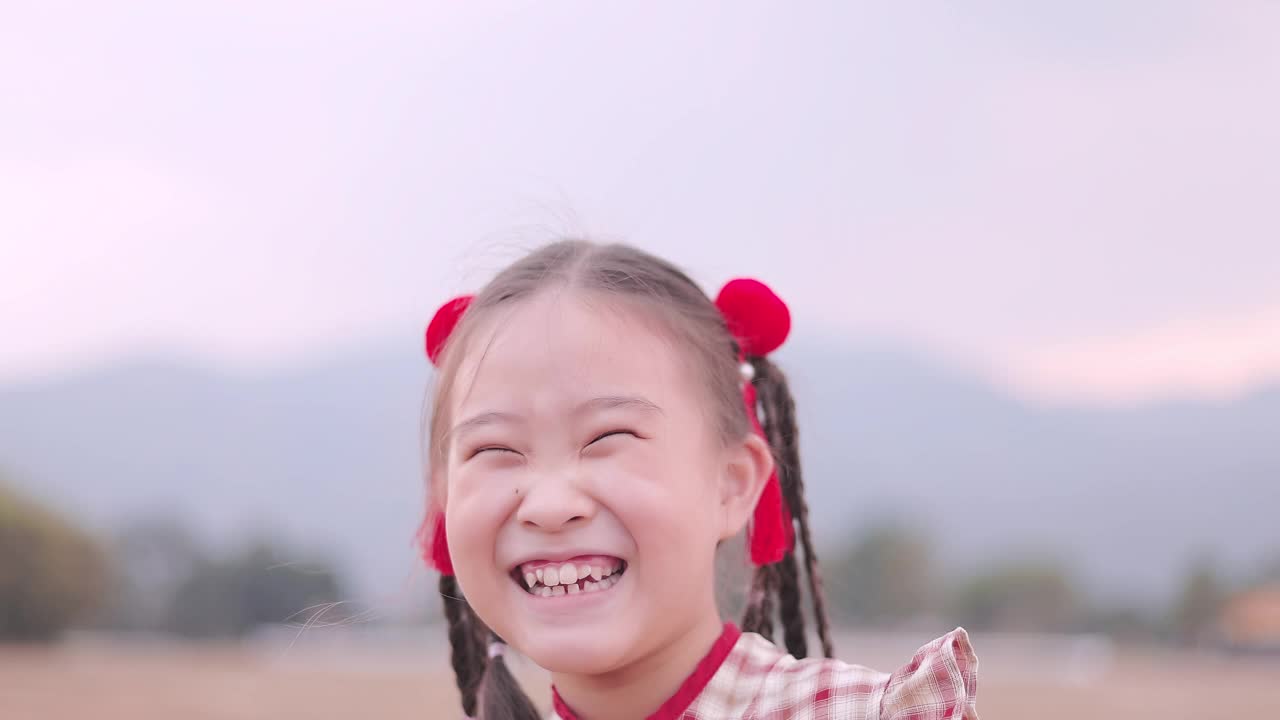 穿着旗袍的亚洲女孩在公园里笑