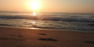 海浪在海滩与天空的橙色光和太阳是在海上股票视频泰国，海滩，日出-黎明，海，日落