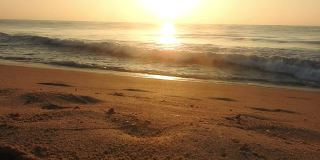 在海滩的海浪与天空桔黄色的光和太阳落在海股票视频泰国，海滩，日出-黎明，海，日落