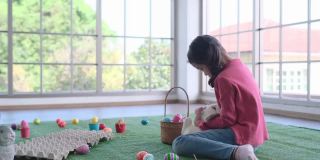 一个小女孩在客厅里拿着复活节彩蛋跳来跳去，另一个女孩在复活节玩白兔