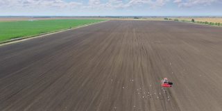 农用拖拉机在农田播种作物的无人机拍摄