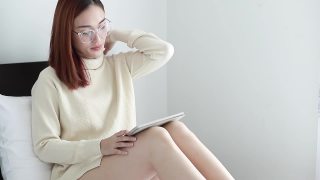 年轻的亚洲美女在网上购物。女性在家中使用数字平板电脑。女孩在室内用平板电脑。轻松支付使用数字小工具的概念视频素材模板下载