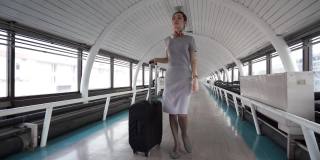 带着旅行袋在机场候机楼或地铁里行走的商务女性