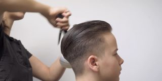 在理发前，女发型师会用喷雾器梳理客户的头发并为其保湿。