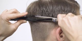 特写的头发剪在后面的头与剪刀和梳子。