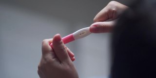 亚洲妇女的手与阳性妊娠测试