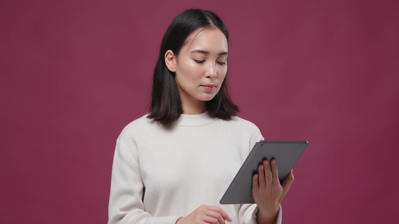 年轻的亚洲快活女人滚动平板电脑对抗马萨拉copyspace