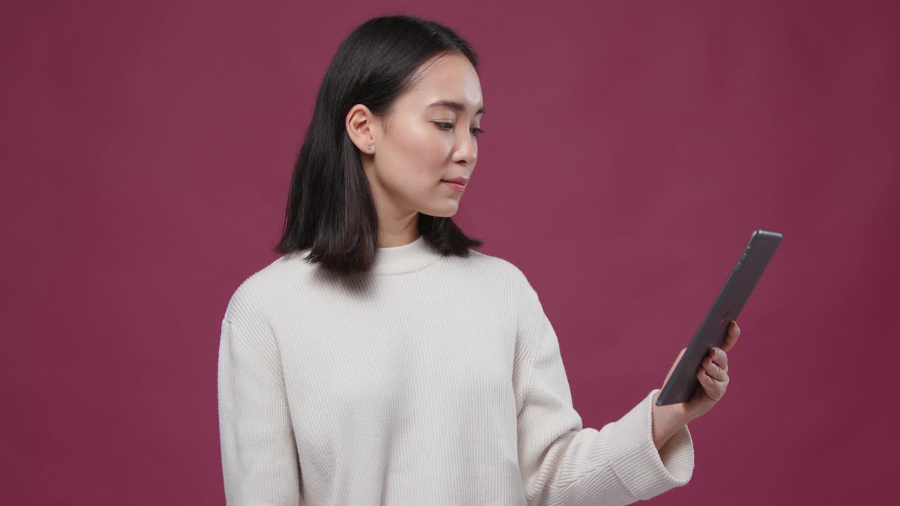 年轻的亚洲快活的女人做视频电话平板电脑对抗马萨拉copyspace
