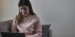 学习使用电脑和电话会议的亚洲妇女