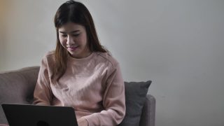 学习使用电脑和电话会议的亚洲妇女视频素材模板下载