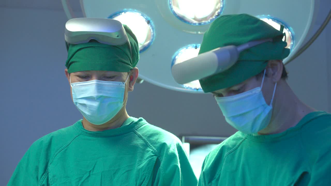 在一家高科技医院的手术室里，一群穿着全套手术服、戴着增强现实耳机的医生正在为病人做手术。医疗技术的概念。