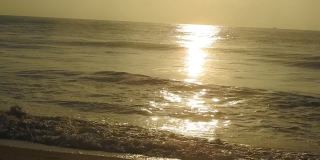 海面上的小波浪日落。金色的夕阳和黄色的阳光。《海边的日落》美丽的海上日落。日落与海浪
