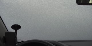 清除汽车挡风玻璃上的积雪，从车内观察。