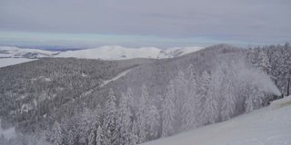 雪机在滑雪坡上爆破人工雪，为滑雪季节的开始做准备