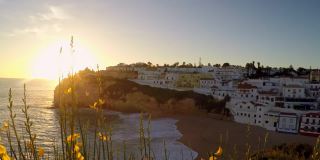 葡萄牙卡沃埃罗悬崖峭壁上梦幻般的日落。远处有很多房子。