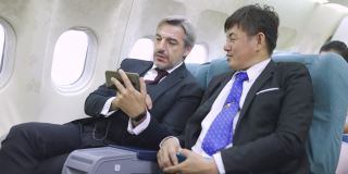 多民族商务人士在飞机上使用手机
