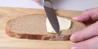 特写:用刀在面包上抹黄油