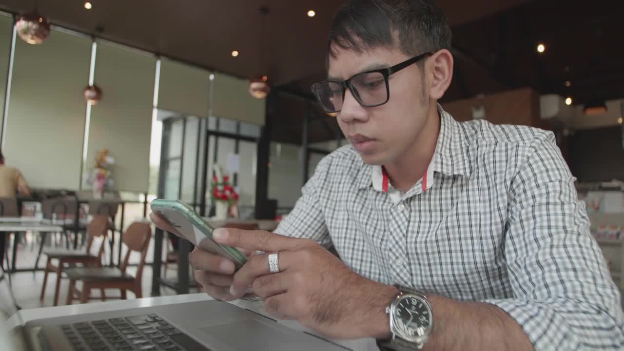 亚洲男性使用手机和笔记本电脑进行网上购物和信用卡支付