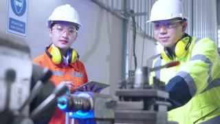 年轻的亚洲工业机器人工程师工作测试和程序机器人手臂在一个研究实验室与现代设备一起。人与科技或创新的观念。视频素材模板下载